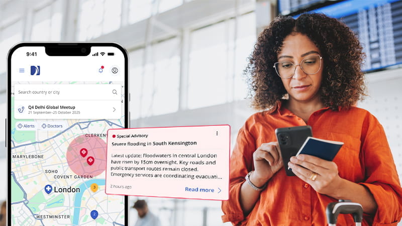 woman business traveler looking at phone notification from international sos' app