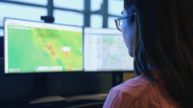 security analyst looking at two monitors in the London assistance center
